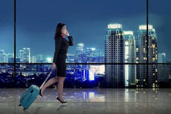 Affärskvinna promenader med resväska över staden bakgrund — Stockfoto