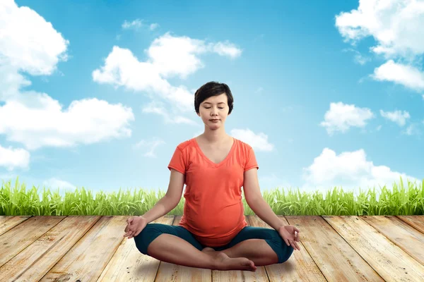 Mujer embarazada haciendo yoga —  Fotos de Stock