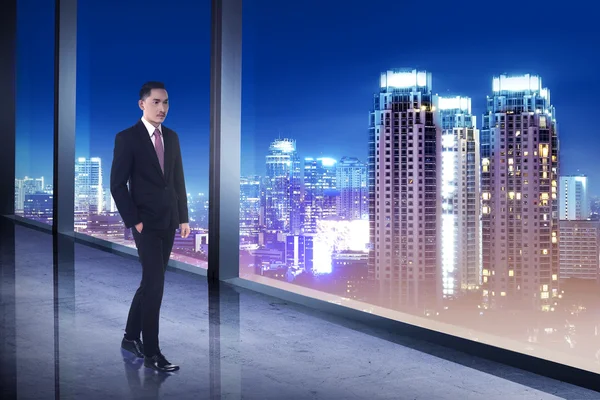 Biznes człowiek patrząc na miasto z jego pomieszczenie biurowe — Zdjęcie stockowe