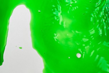 Canlı yeşil sıvının yakın görüntüsü. Canlandırıcı ve dinamik soyut bir arkaplan oluşturuluyor