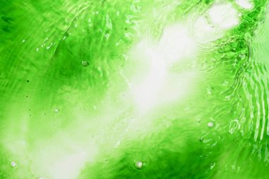 Canlı yeşil sıvının yakın görüntüsü. Canlandırıcı ve dinamik soyut bir arkaplan oluşturuluyor