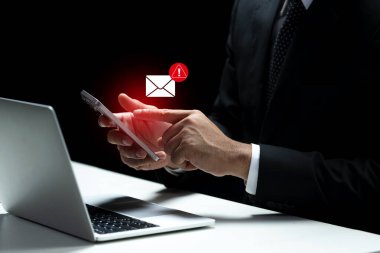 İş adamı cep telefonunu kontrol ediyor. Zararlı olabilecek bir e-postaya işaret eden bir tebligat ile. Dolandırıcılık ya da sahtekarlık kavramı
