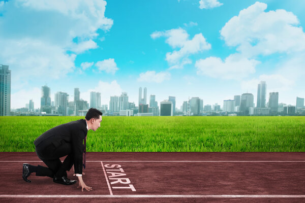 Businessman in ready position to race