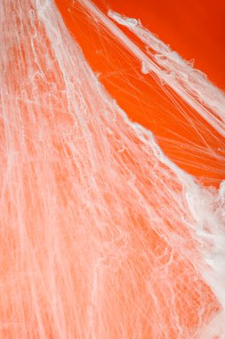 Turuncu arka planda beyaz örümcek ağıyla ürkütücü Cadılar Bayramı dekorasyonu. Model, kopyalama alanı ya da şablon. Cadılar Bayramı partileri ya da ürkütücü projeler için harika bir ortam.