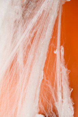 Turuncu arka planda beyaz örümcek ağıyla ürkütücü Cadılar Bayramı dekorasyonu. Model, kopyalama alanı ya da şablon. Cadılar Bayramı partileri ya da ürkütücü projeler için harika bir ortam.