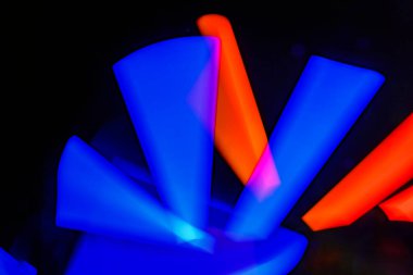 Bulanık efektli ışık resminin soyut görüntüsü. Karanlık arka planda renkli parlak ışıklar kıvrılıyor. Duvar kağıdı, arkaplan veya tasarım ögesi olarak kullanılabilir