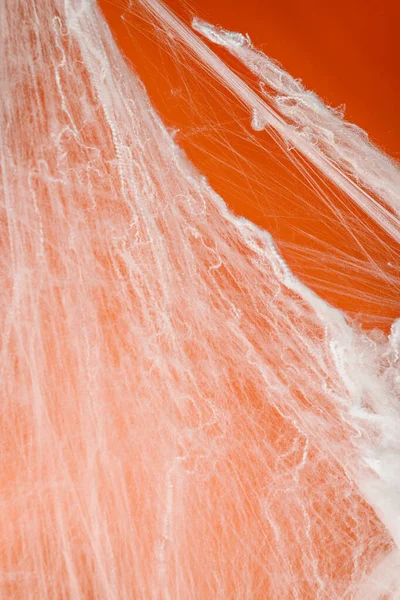 Turuncu arka planda beyaz örümcek ağıyla ürkütücü Cadılar Bayramı dekorasyonu. Model, kopyalama alanı ya da şablon. Cadılar Bayramı partileri ya da ürkütücü projeler için harika bir ortam.