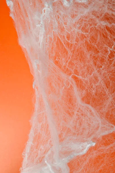 Turuncu arka planda beyaz örümcek ağıyla ürkütücü Cadılar Bayramı dekorasyonu. Model, kopyalama alanı ya da şablon. Cadılar Bayramı partileri ya da ürkütücü projeler için harika bir ortam.