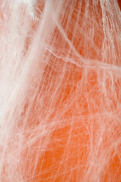 Turuncu arka planda beyaz örümcek ağıyla ürkütücü Cadılar Bayramı dekorasyonu. Model, kopyalama alanı ya da şablon. Cadılar Bayramı partileri ya da ürkütücü projeler için harika bir ortam.