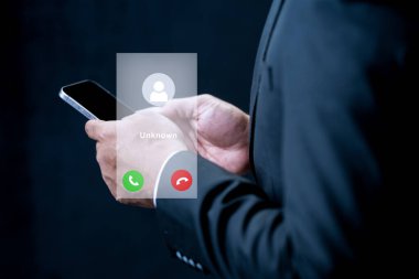 Takım elbiseli bir işadamı, bilinmeyen bir arama için dijital arayüz içeren bir akıllı telefon tutuyor. Mahremiyet, iletişim ve dijital güvenlik kavramı