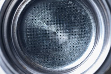 Küçük deliklerin dairesel desenlerini ve paslanmaz çelik dokusunu gösteren metal bir espresso makinesinin ayrıntılı makro görüntüsü. Kahveyle ilgili kavramlar için ideal