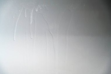 Dikey sıvı çizgileri ve damlaları içeren gri boyalı bir yüzeye yakından bakmak tasarım projeleri için grunge endüstriyel bir zemin oluşturur.