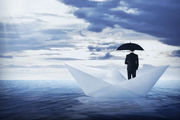 Asian business man holding umbrella standing on the paper boat — Stock Photo, Image