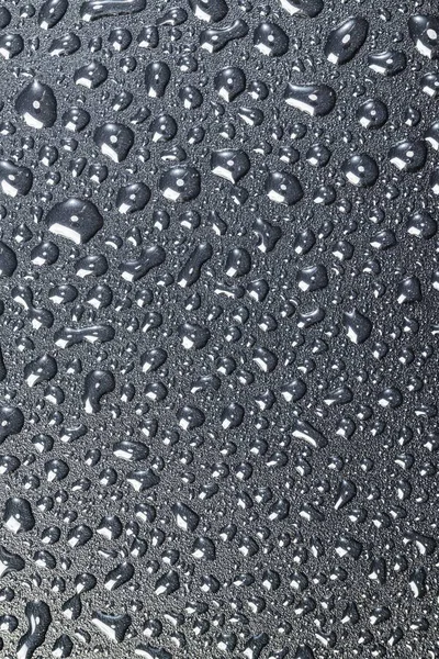 Siyah dokulu arkaplanda beyaz sıvı damlalarının yakın görüntüsü