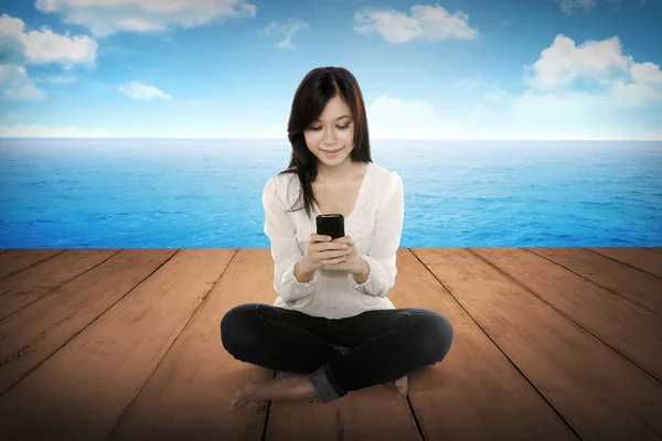 Досить азіатська дівчина використовує мобільний телефон — стокове фото
