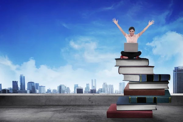 Business person working with laptop on  the top of books