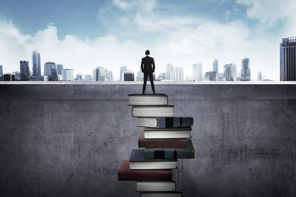 Επιχειρηματίας που στέκεται στην κορυφή τα βιβλία — Φωτογραφία Αρχείου
