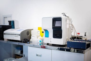 Klinik bir ortamda paslanmaz çelik bir tezgahın üzerinde duran modern tıbbi laboratuvar analiz ekipmanlarını kapatın. Teşhis araçları ve tıbbi malzemeler görünür.