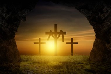 Paskalya sabahı İsa 'nın dirilişini simgeleyen altın bir gündoğumu sırasında tepedeki üç haça bakarak boş bir mezardan bakmak.