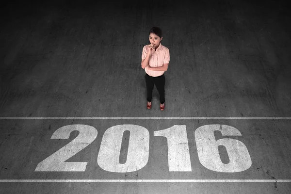 Businesswoman looking 2016 number on the floor — Stock Photo, Image