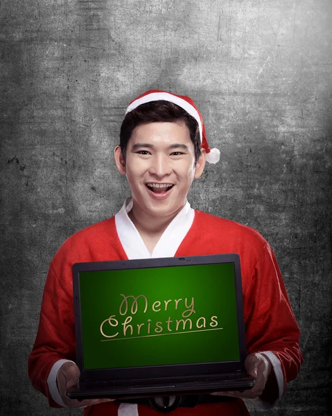 Weihnachtsmann hält Laptop mit frohem Weihnachtsbrief in der Hand — Stockfoto