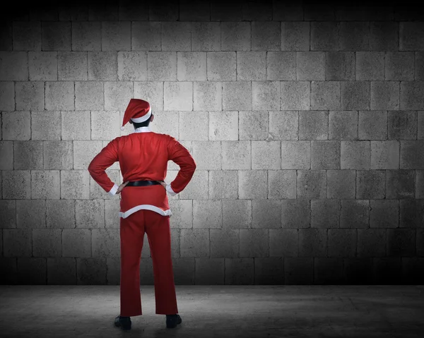 Man in santa claus kostuum kijken naar de muur — Stockfoto