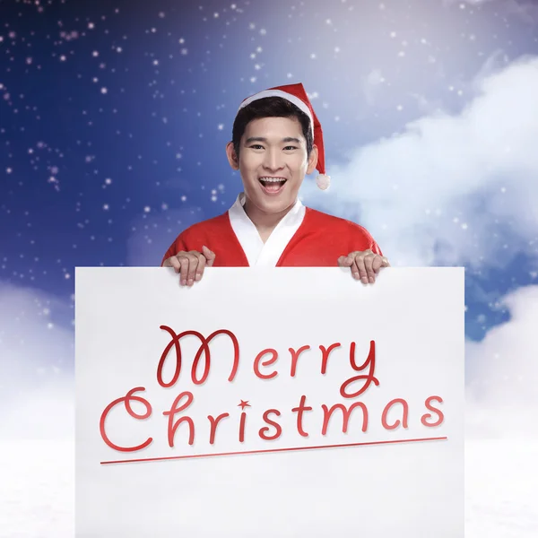 Ο άνθρωπος φορώντας κοστούμι Άγιος Βασίλης, κρατώντας πανό με χαρούμενα Χριστούγεννα γραφής — Φωτογραφία Αρχείου