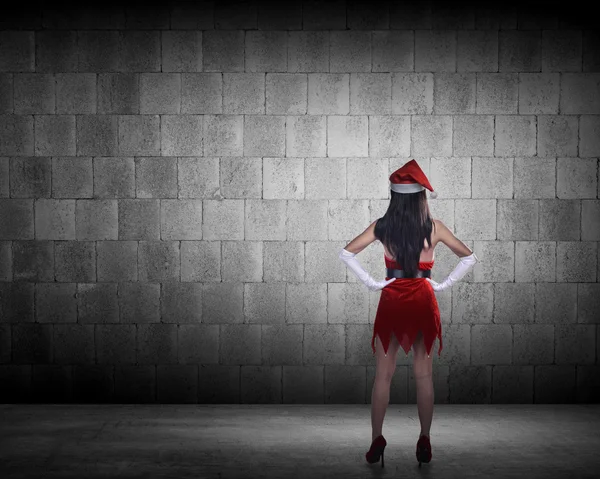 Mulher em Santa Claus traje olhando para a parede — Fotografia de Stock