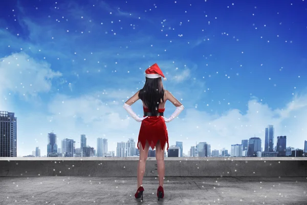 Woman wearing santa claus costume, standing on the rooftop — Stock Photo, Image