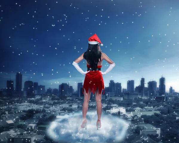 Frau im Weihnachtsmannkostüm steht auf der Wolke — Stockfoto