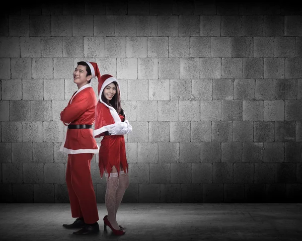 Happy couple in santa claus costumes — Stock Photo, Image