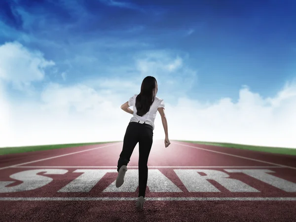 Businesswoman running from start line — Stock Photo, Image