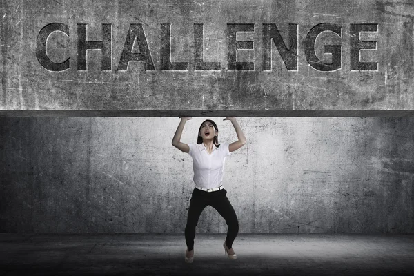 Asian businesswoman lifting heavy block — Stock Photo, Image