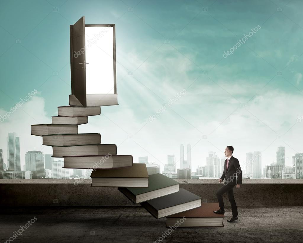 businessman stepping up stair made from books
