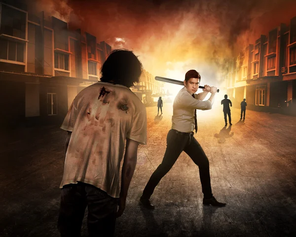 Man with bat fighting against zombies — Stock Photo, Image