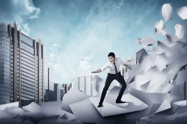Asiatiska affärsman surfa på vågen av papper — Stockfoto
