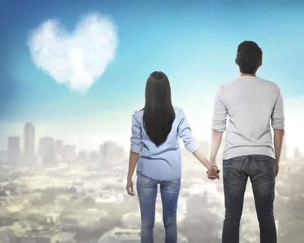 Couple holding hands and looking at the sky — Stock Photo, Image