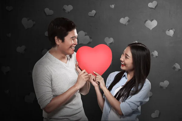 Encantador casal segurando coração vermelho — Fotografia de Stock