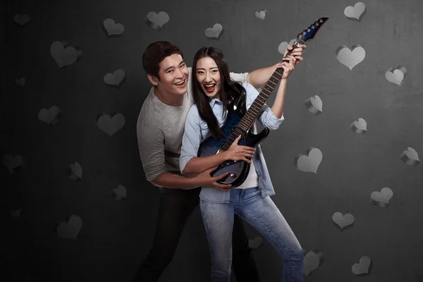 Милая азиатская пара, играющая на гитаре — стоковое фото