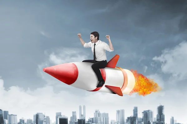 Азіатський бізнесмен літає ракетою — стокове фото