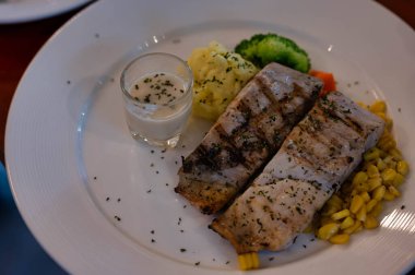 Lezzetli balık bifteği ve soslu sebze.