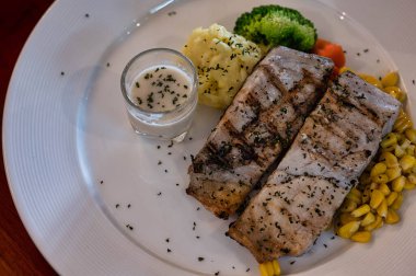 Lezzetli balık bifteği ve soslu sebze.