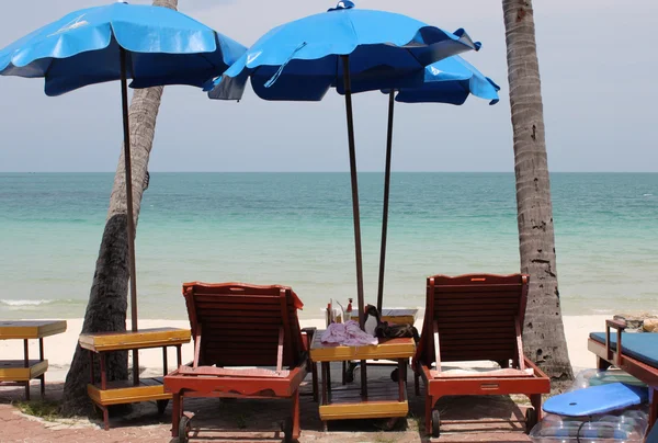 Parapluies, chaises longues et tables sur la plage — Photo