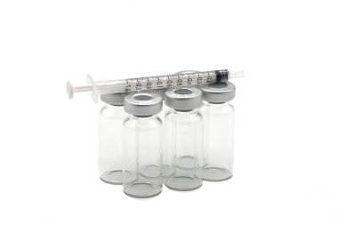 Altı tıbbi aşı ampulü ve beyaz arka planda ampullerin üzerinde duran bir şırınga..