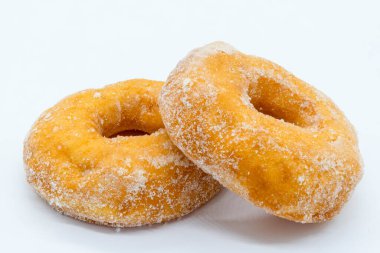 İki şekerli ve bol yağda kızartılmış çörek. Biri diğerinin üzerinde dinleniyor. Kafe menüsü ya da şarküteri için iyi görüntü.