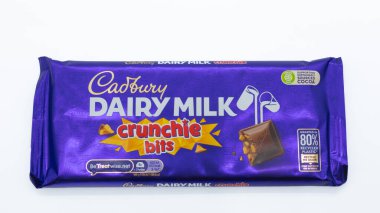 Irvine, İskoçya, İngiltere - 27 Kasım 2025: Cadbury markalı Süt Barları ve Crunchie bitleri, resim ile ilgili resim grafikleri ve simgeleri gösteren ambalajlar.
