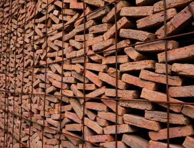 Stacked Red Clay Bricks in Construction Site - Traditional Building Materials Organized in Storage Rows for Architecture Project.