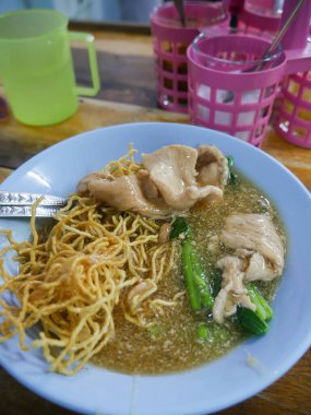 Crispy Fried Noodles with Wonton Dumplings in Thick Gravy Sauce - Traditional Chinese Thai Noodle Dish.