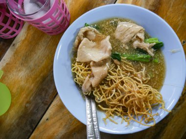 Crispy Fried Noodles with Wonton Dumplings in Thick Gravy Sauce - Traditional Chinese Thai Noodle Dish.