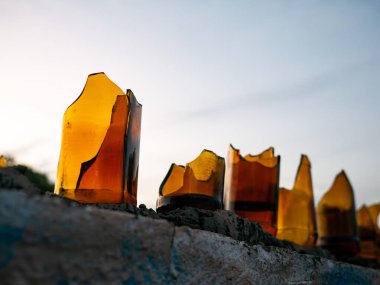 Kırık Kehribar Şişeleri Duvarda Dramatik Akşam Gökyüzüne Karşı - Geleneksel Güvenlik Bariyeri Silueti